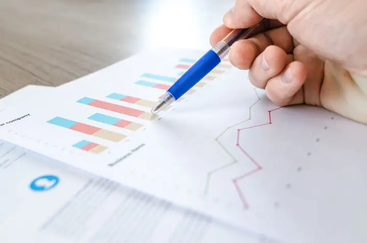 Hand reviewing charts and graphs on a monitoring report