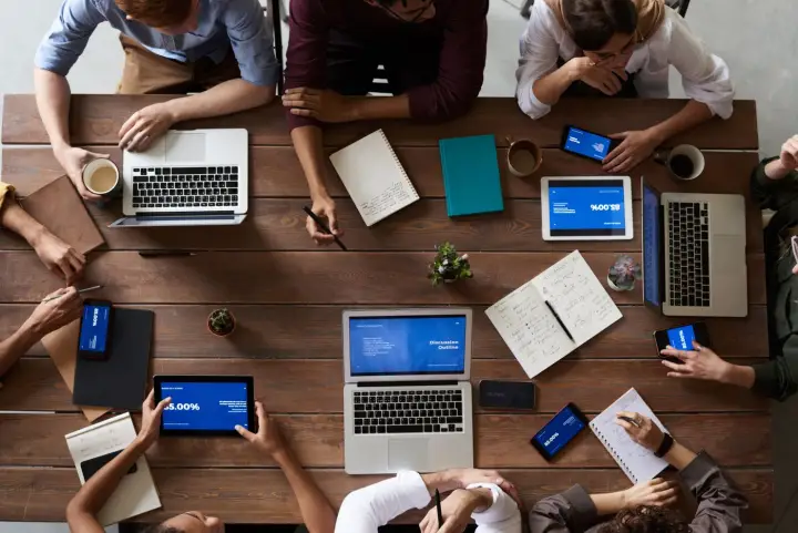 Team collaborating with laptops and tablets on connected application workflows